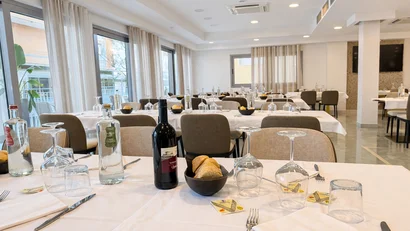 Hotel Regal: comfort ed eleganza a Rimini Ristorante con tavoli apparecchiati con bottiglie, calici, pane e posate