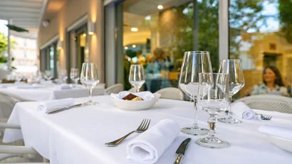 Hotel Regal: comfort ed eleganza a Rimini Tavolo all'aperto apparecchiato con tovaglia bianca, posate e calici vuoti.